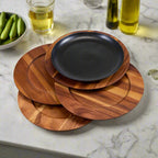 Stack of wooden coasters with a black plate on a marble surface