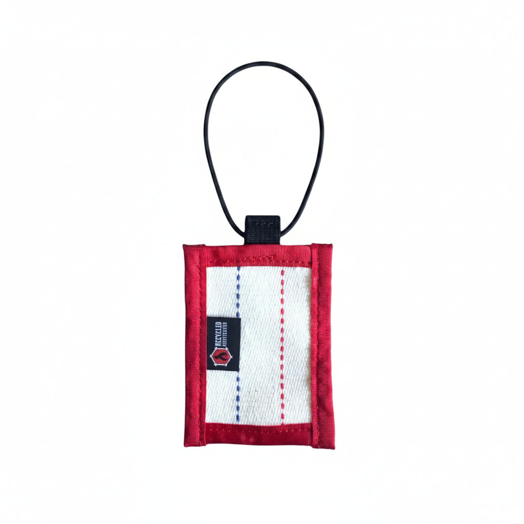 Small red and white pouch with a black strap on a white background