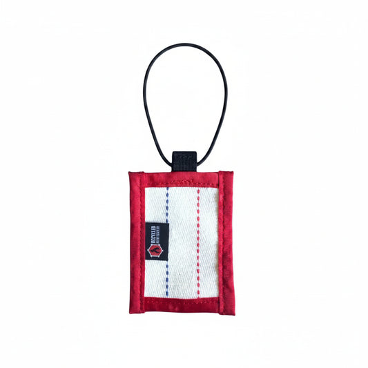 Small red and white pouch with a black strap on a white background